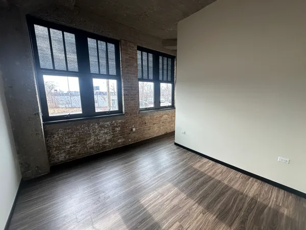 a view of wooden floor and windows in a room