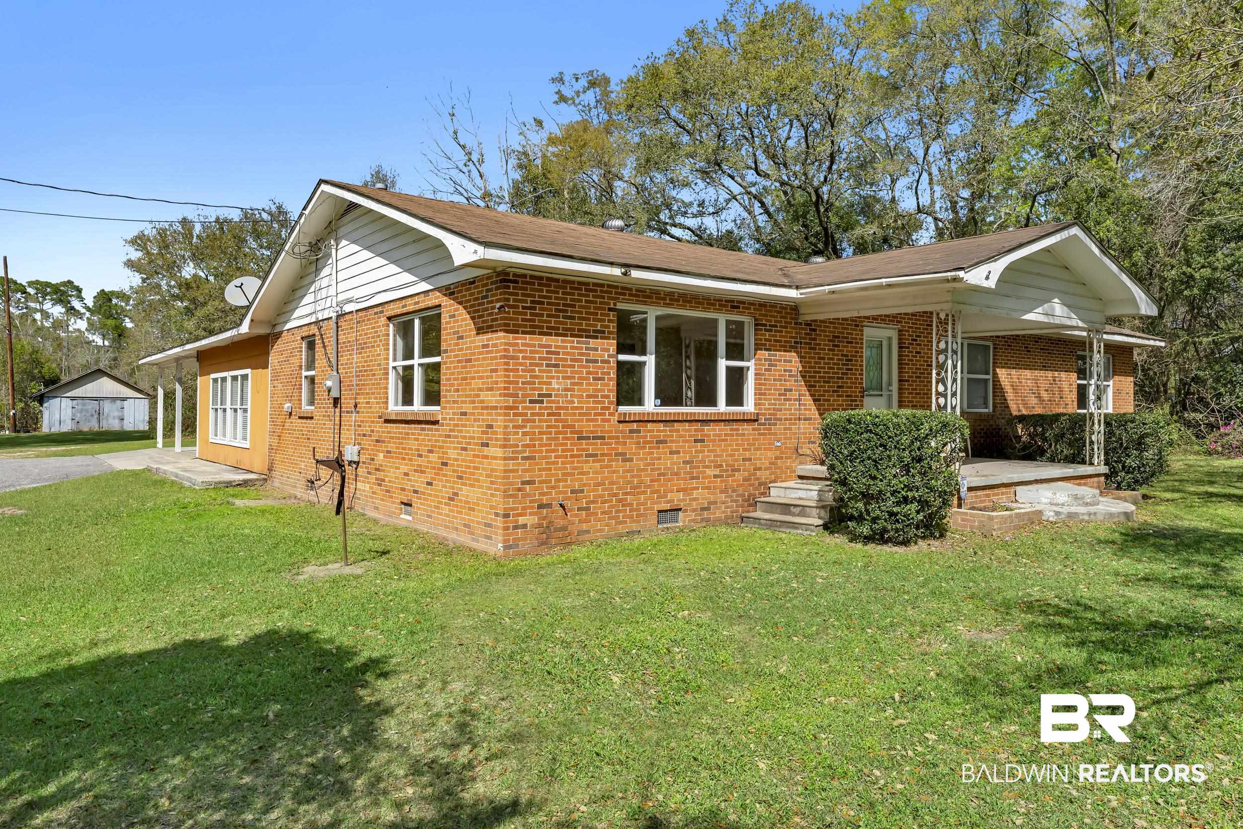 17463 Highway 98 Foley, AL 36535 - Photo 24 of 57 View of side of property featuring crawl space, brick siding, and a lawn