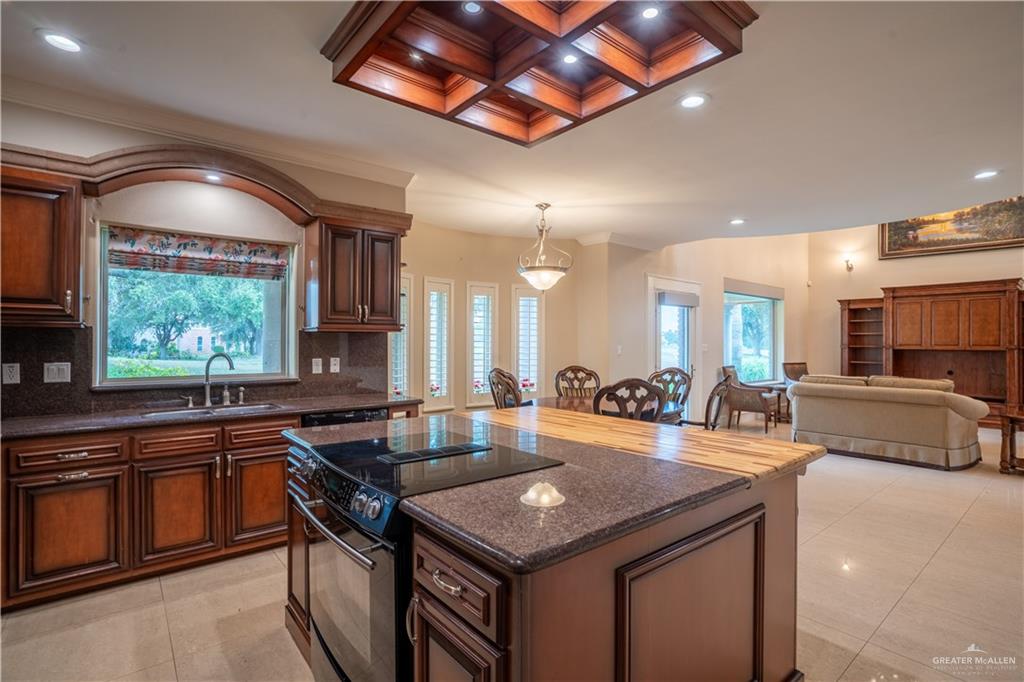 2013 Sabinal Street Mission, TX 78572 - Photo 13 of 33 a kitchen with stainless steel appliances granite countertop a sink a stove and a wooden cabinets