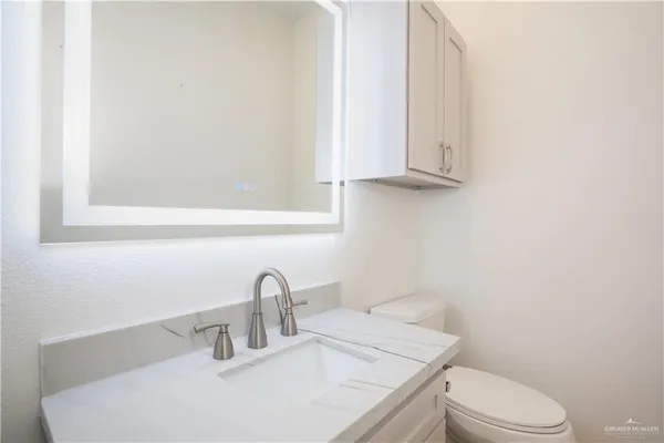 a bathroom with a sink a toilet and vanity