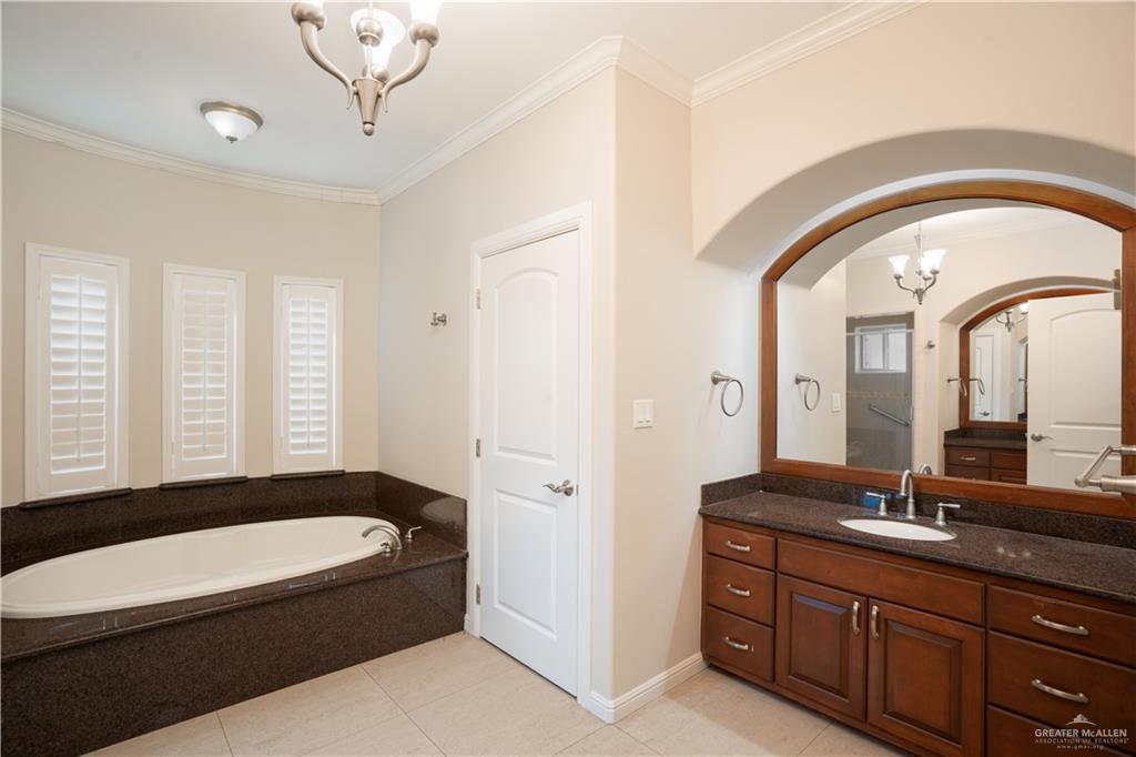 2013 Sabinal Street Mission, TX 78572 - Photo 24 of 33 a bathroom with a granite countertop bathtub a sink and a large mirror