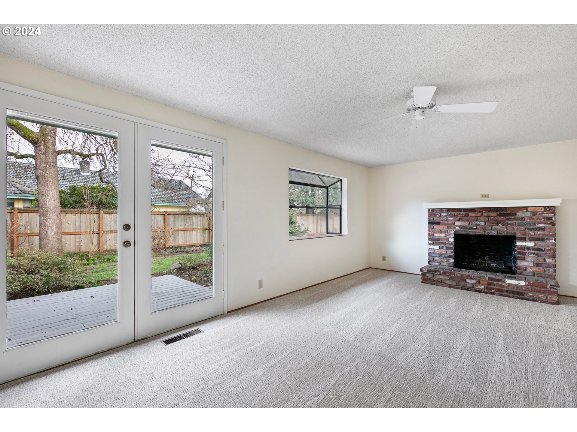 609 Rowan Avenue Springfield, OR 97477 - Photo 13 of 32 a view of an empty room with a fireplace and a window