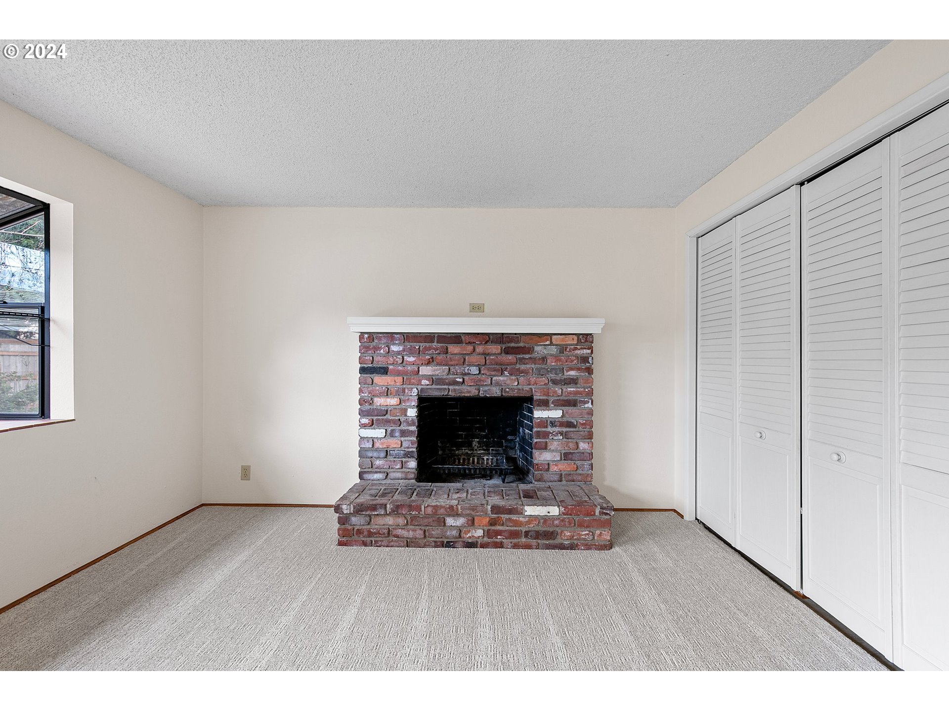 609 Rowan Avenue Springfield, OR 97477 - Photo 14 of 32 a living room with a fireplace and a wooden floor
