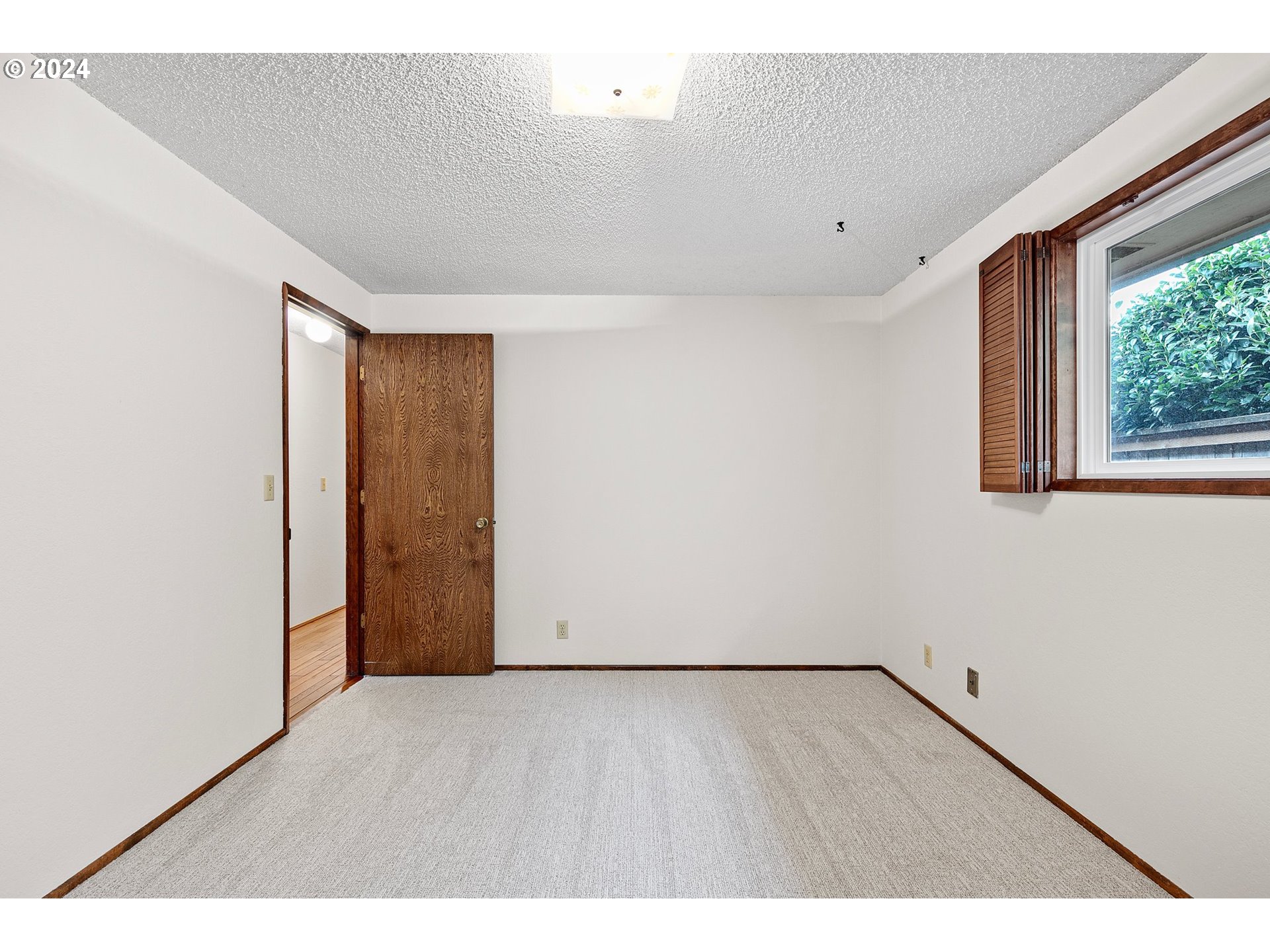 609 Rowan Avenue Springfield, OR 97477 - Photo 19 of 32 a view of an empty room with wooden floor and a window