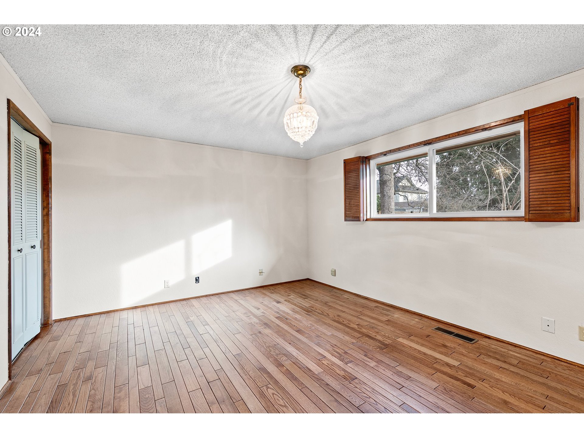 609 Rowan Avenue Springfield, OR 97477 - Photo 25 of 32 a view of an empty room with wooden floor and window