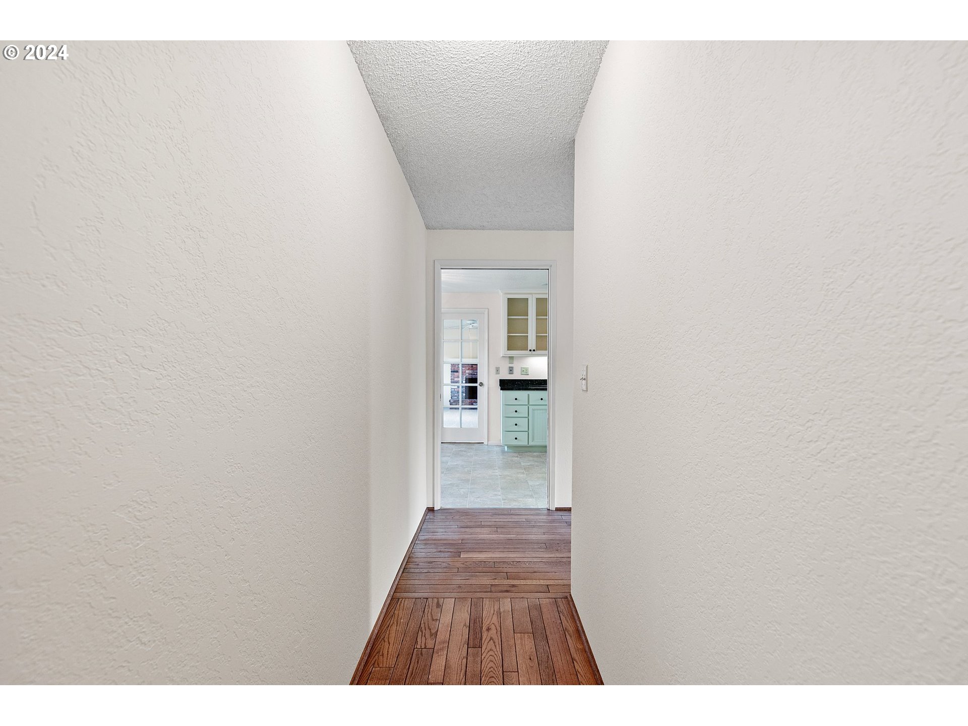 609 Rowan Avenue Springfield, OR 97477 - Photo 6 of 32 a view of a hallway with wooden floor