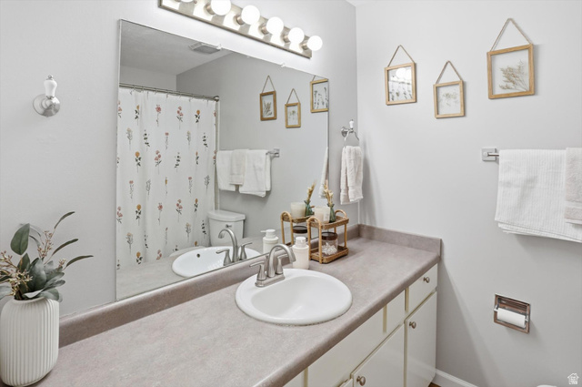 8938 Manchester Lane Sandy, UT 84093 - Photo 22 of 50 Bathroom featuring an expansive vanity with an integrated sink and brushed nickel faucet