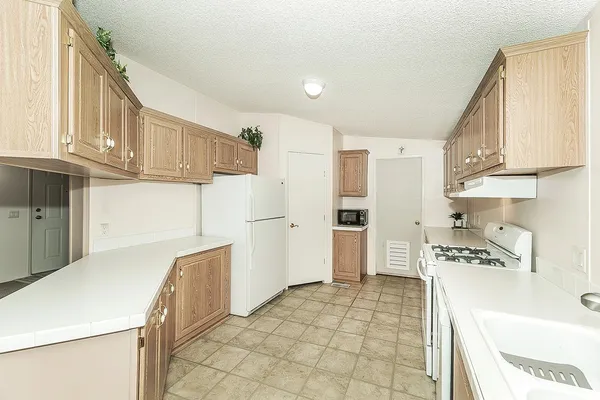 a kitchen with a sink a refrigerator and cabinets