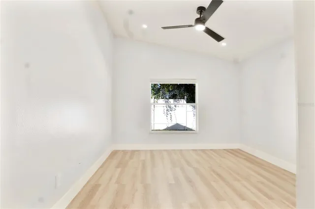 an empty room with a window and a fan