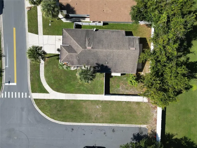 an aerial view of a house with a yard and trees