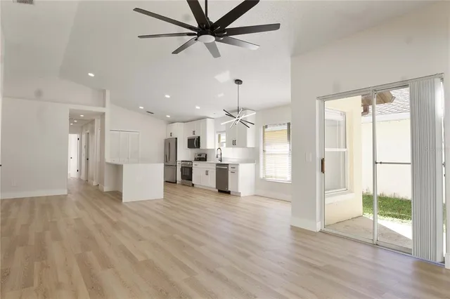a view of a kitchen with wooden floor and a ceiling fan