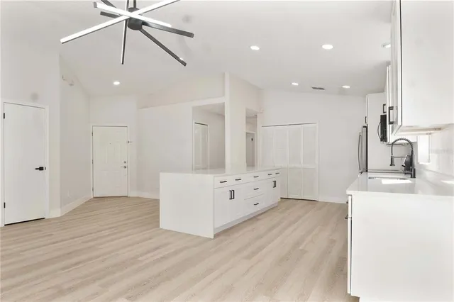 a kitchen with white cabinets and sink