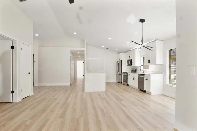 a view of kitchen with stainless steel appliances refrigerator stove microwave and cabinets