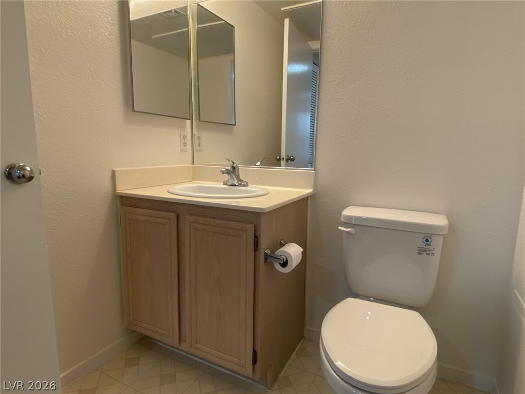 8070 West Russell Road, Unit 2105 Las Vegas, NV 89113 - Photo 9 of 10 A well-maintained lavatory featuring a vanity, sink, and toilet, suitable for daily routines.