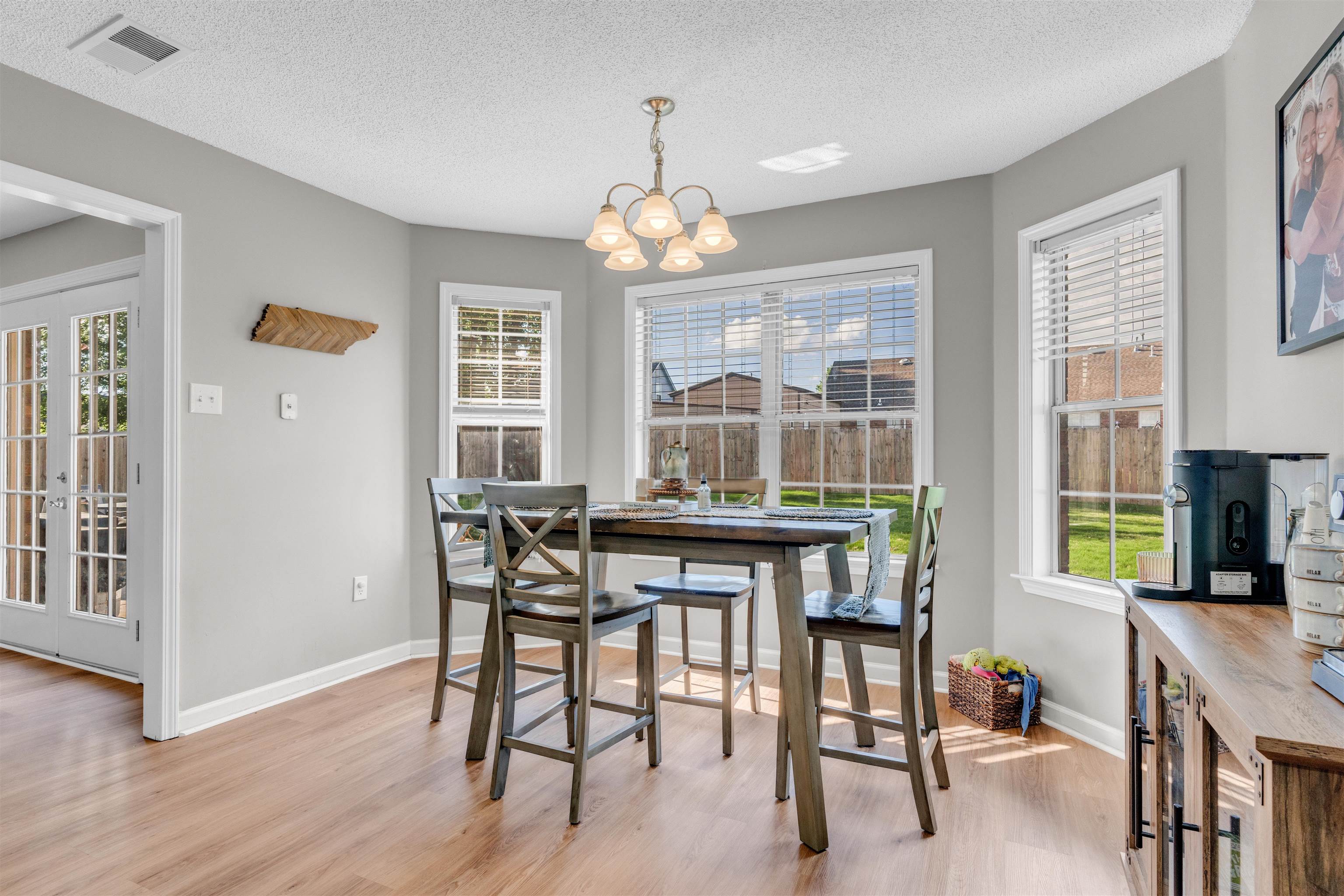 126 Buck Stand Road Atoka, TN 38004 - Photo 8 of 21 Dining space featuring light wood-style floors, a chandelier, a textured ceiling, and healthy amount of natural light