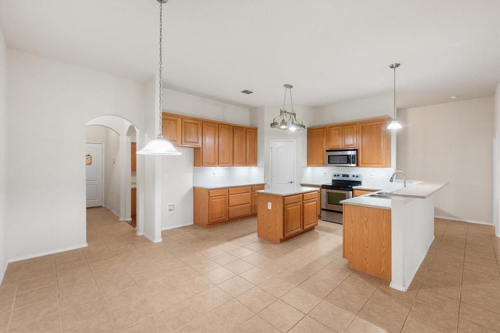10929 Soft Shell Drive Venus, TX 76084 - Photo 19 of 39 a view of kitchen with stainless steel appliances kitchen island granite countertop refrigerator stove microwave and cabinets