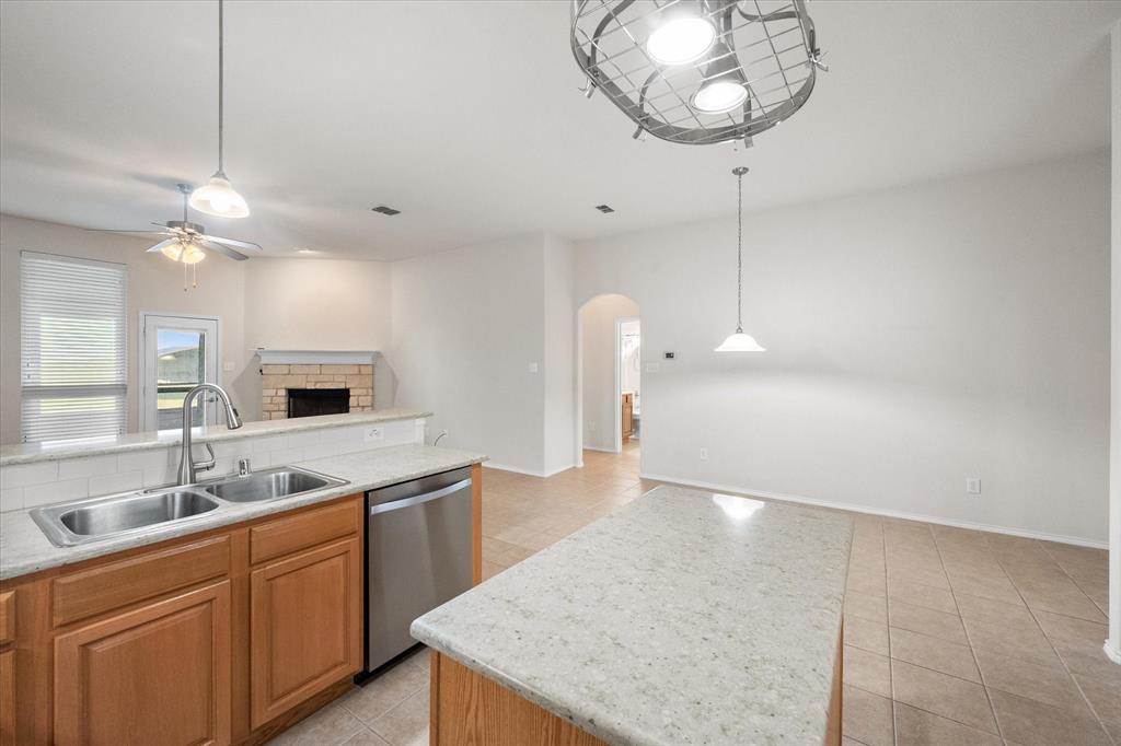 10929 Soft Shell Drive Venus, TX 76084 - Photo 24 of 39 a kitchen with kitchen island granite countertop a sink a counter space appliances and cabinets