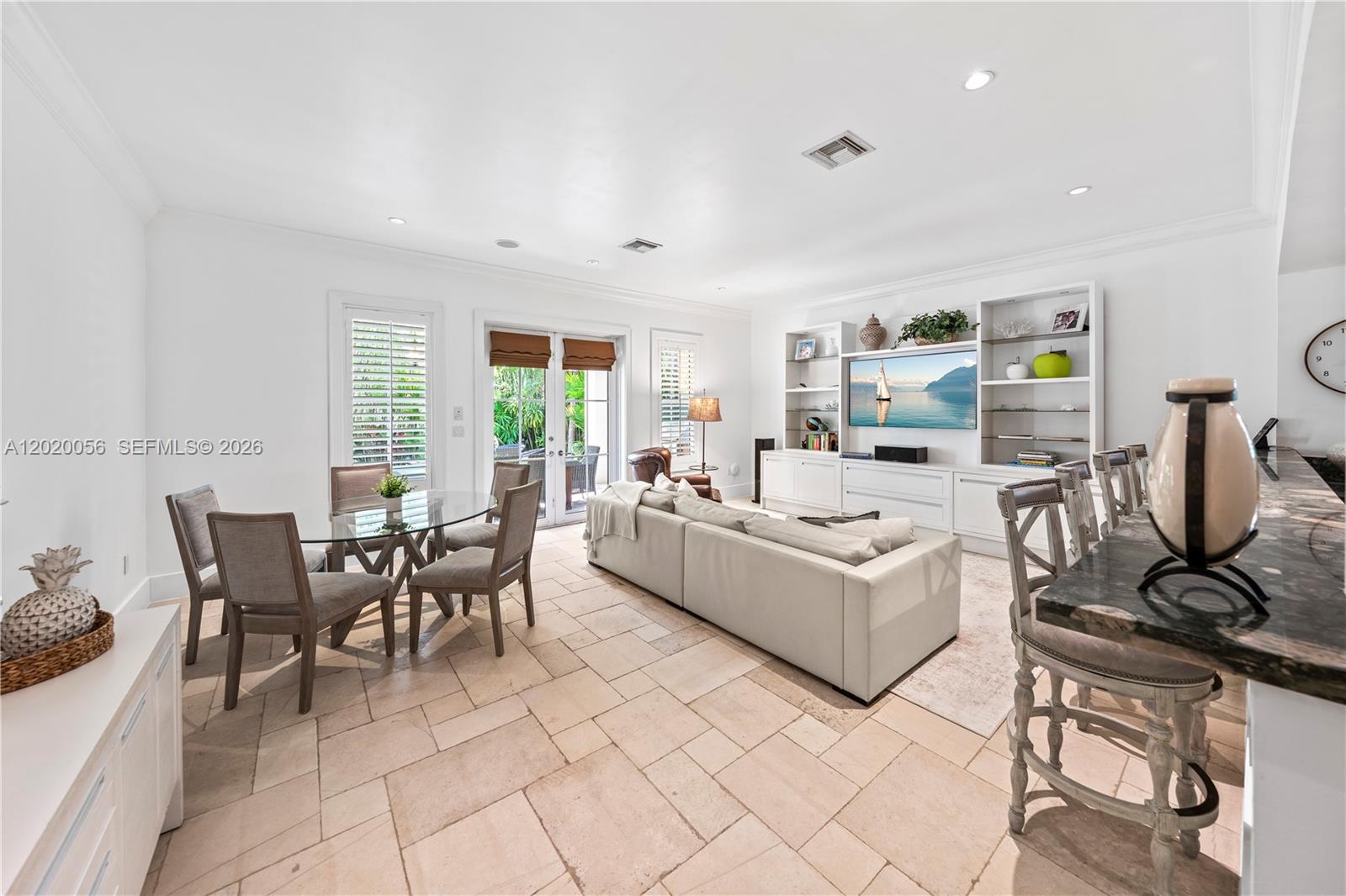4196 Douglas Road Miami, FL 33133 - Photo 35 of 96 a living room with furniture a dining table and a bookshelf