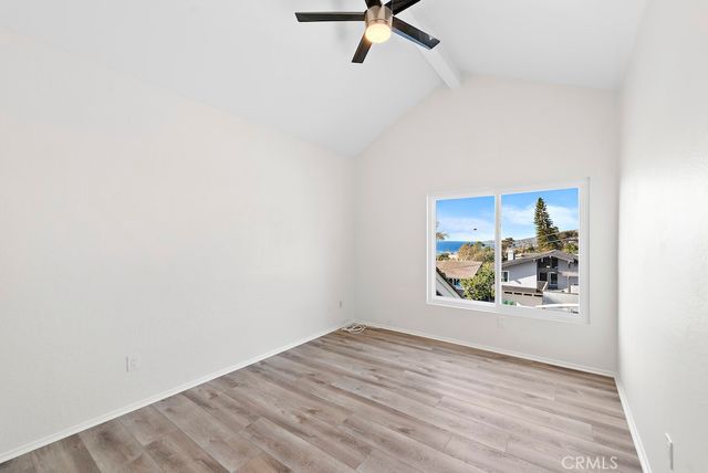 a view of a hallway with wooden floor and a window