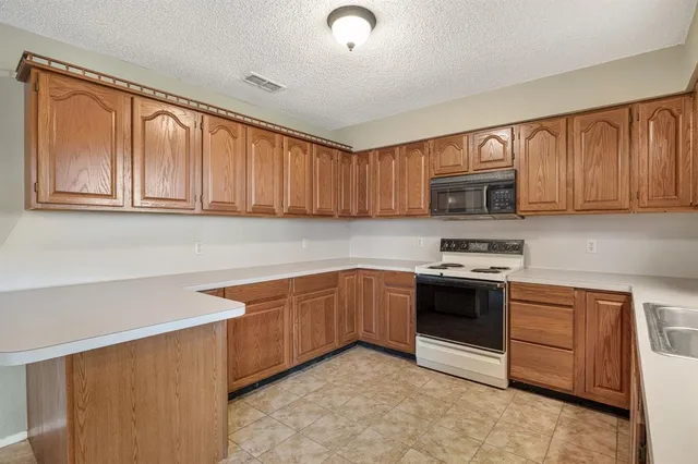 a kitchen with stainless steel appliances granite countertop a stove a sink dishwasher and a microwave oven on the blue kitchen countertops