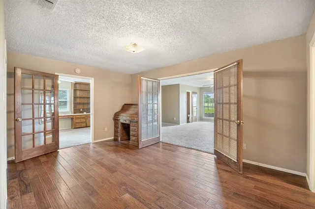 an empty room with wooden floor and fireplace