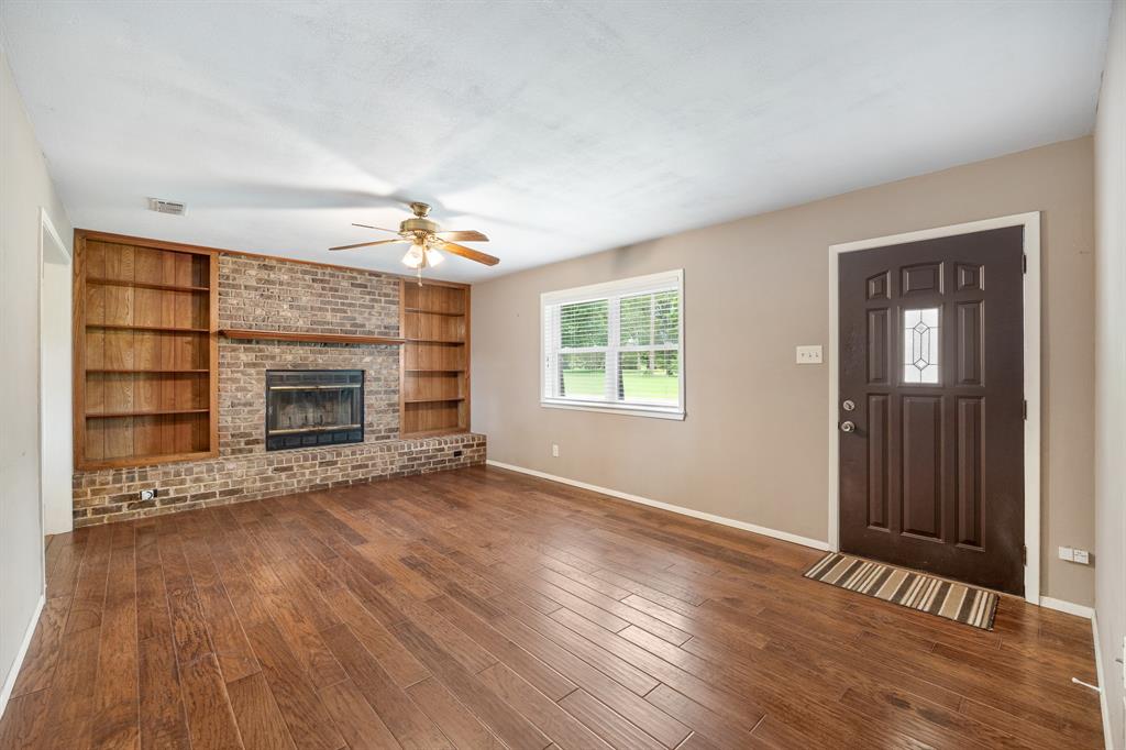 24264 State Highway Canton, TX 75103 - Photo 4 of 38 an empty room with wooden floor fireplace and windows
