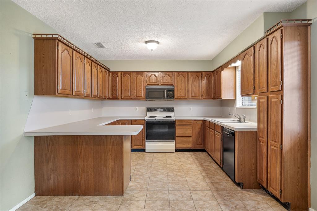 24264 State Highway Canton, TX 75103 - Photo 10 of 38 a kitchen with stainless steel appliances granite countertop wooden cabinets a stove top oven a sink and dishwasher