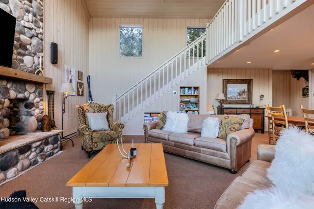 a living room with furniture kitchen view and a wooden floor