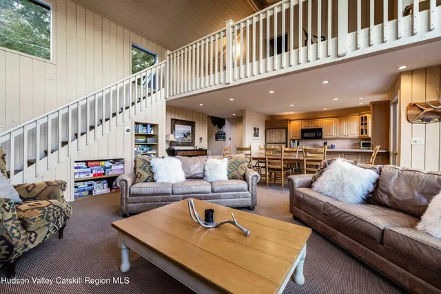 a living room with furniture a flat screen tv and a large window
