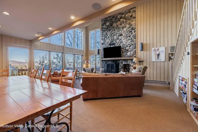 a dining room with stainless steel appliances granite countertop a table chairs and a refrigerator