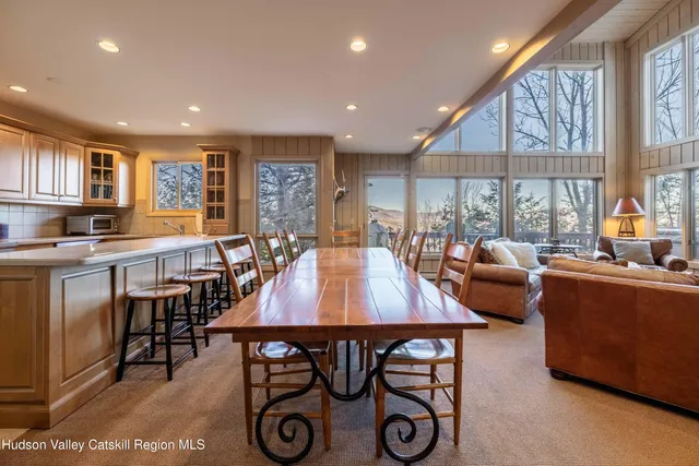 a kitchen with stainless steel appliances granite countertop a table chairs refrigerator and a sink