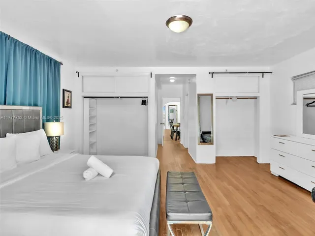 a view of a bedroom with furniture and wooden floor