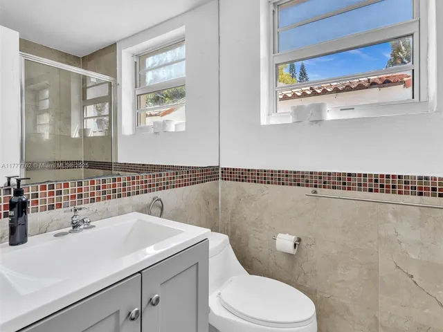 a bathroom with a sink a toilet and a mirror