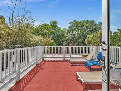 a balcony with chairs and wooden fence