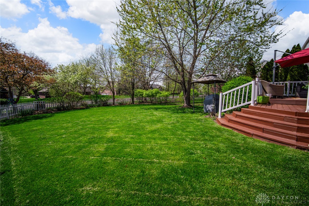 55 Janney Lane Springboro, OH 45066 - Photo 10 of 38 This spacious yard features lush green grass, a charming picket fence, and a welcoming deck perfect for outdoor enjoyment.