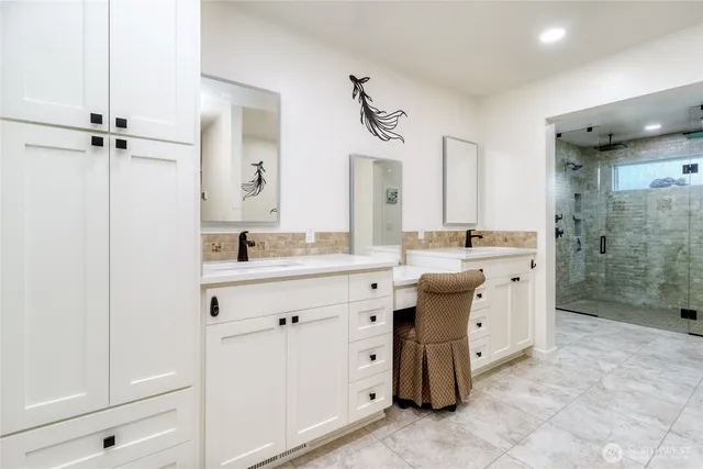 a bathroom with a double vanity sink mirror and shower