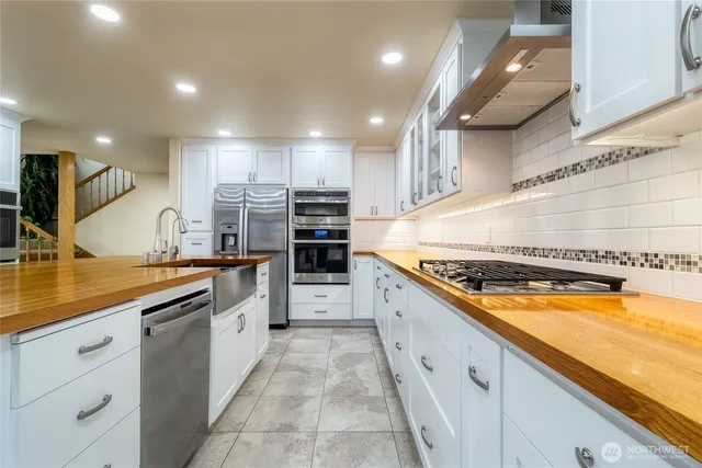 a large kitchen with stainless steel appliances granite countertop lots of counter top and sink