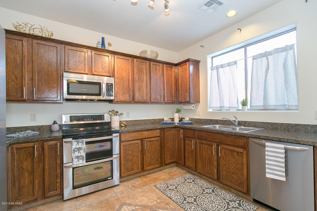 39103 Winners Circle Tucson, AZ 85739 - Photo 3 of 19 a kitchen with stainless steel appliances granite countertop a sink stove and microwave