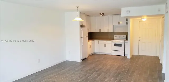 a kitchen with a refrigerator and a stove top oven
