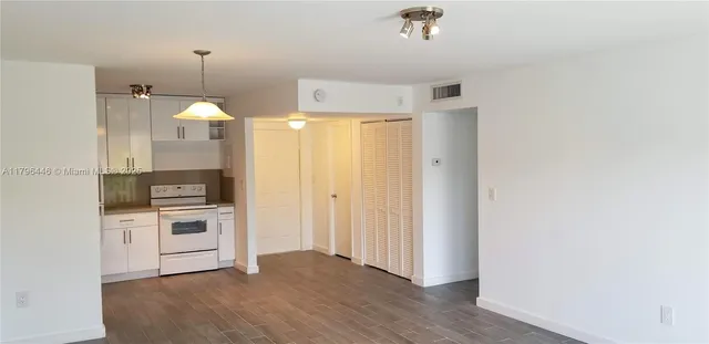 a kitchen with kitchen island white cabinets and stainless steel appliances