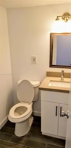 a white toilet sitting next to a bathroom sink
