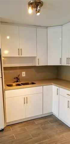 a view of a kitchen sink and cabinet