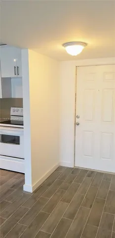 a view of empty room with wooden floor and cabinets