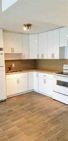 a kitchen with granite countertop white cabinets and white appliances