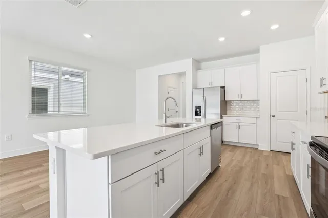a kitchen with a sink cabinets and wooden floor