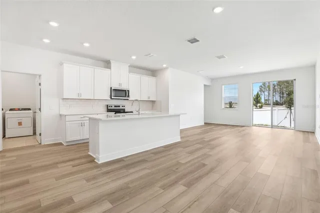 a view of a kitchen with wooden floor and a window