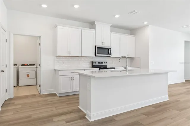 a kitchen with stainless steel appliances a refrigerator sink and cabinets