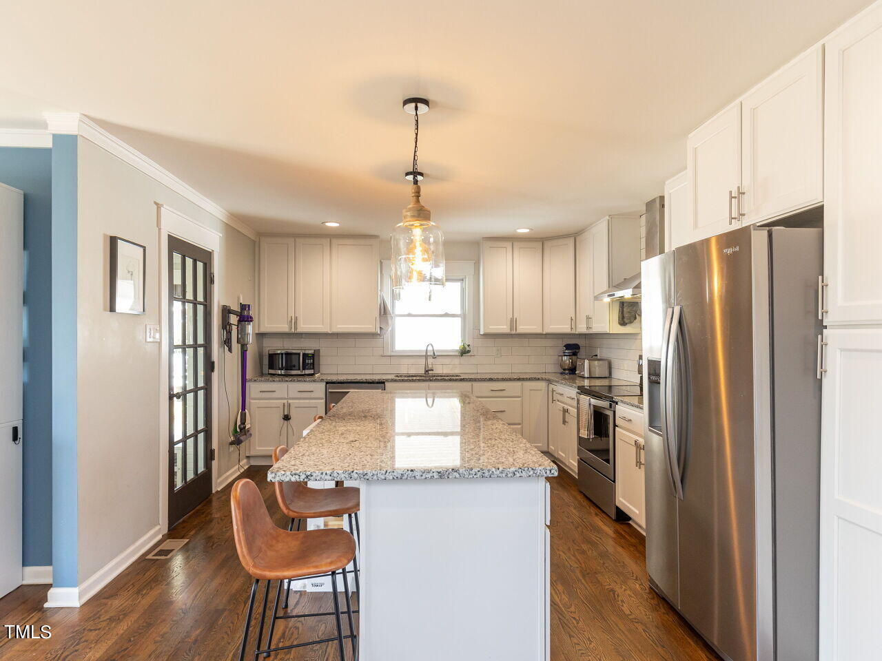 125 Crestview Drive Durham, NC 27712 - Photo 12 of 30 a kitchen with stainless steel appliances granite countertop a refrigerator a stove a sink a dining table and chairs with wooden floor