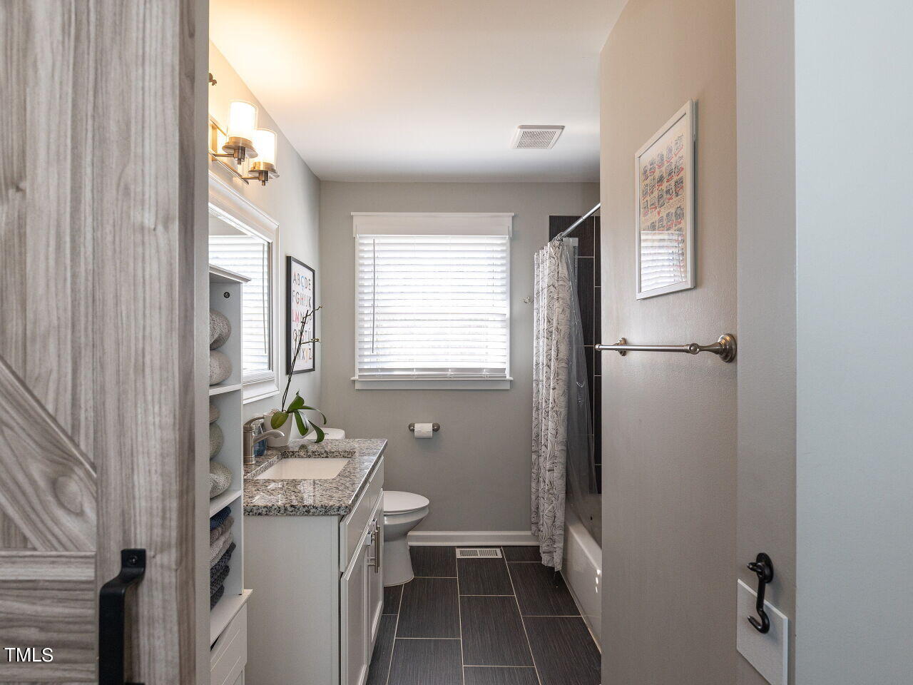 125 Crestview Drive Durham, NC 27712 - Photo 16 of 30 a bathroom with a granite countertop sink toilet a mirror and shower