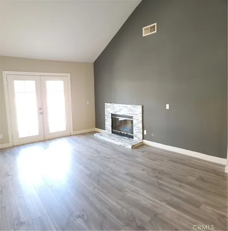 a view of empty room with wooden floor and fireplace